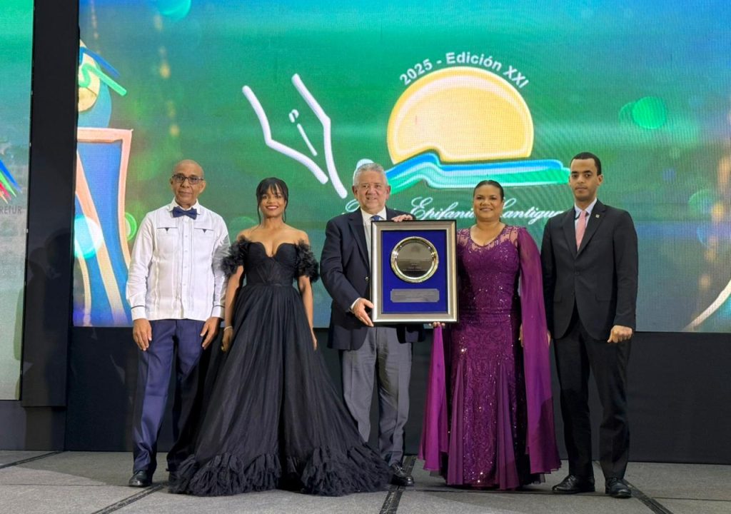 El viceministro Roberto Henríquez recibe la placa de renococimiento otorgada al ministro de Turismo, David Collado.