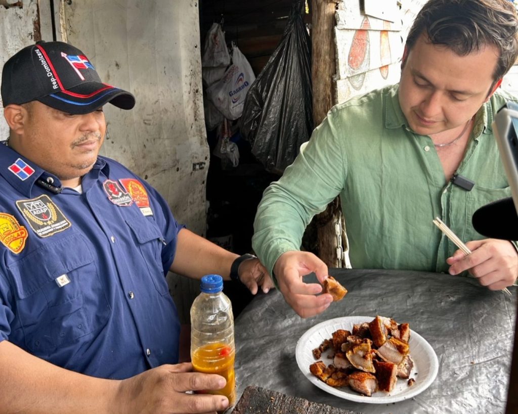 Calixto Serna degustando chicharrones de cerdo en Villa Mella.