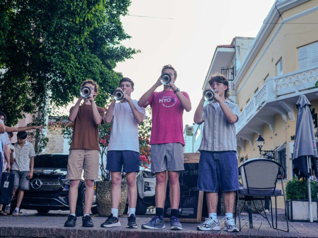 Los jóvenes músicos del Carnegie Hall acercan la música orquestal al público reunido en la plaza de España.